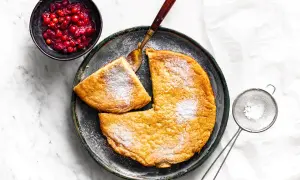 Puszysty omlet, posypany cukrem pudrem, z żurawiną obok. Idealny przepis na pyszne śniadanie.