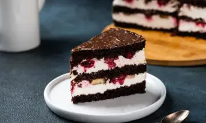 Obłędny tort czekoladowy z mascarpone i owocami, z malinami i bananem, polany czekoladą.