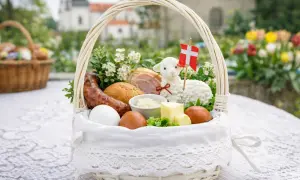 Biały koszyczek wielkanocny z barankiem, jajkami, kiełbasą i masłem. Idealny do święconki.