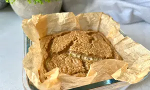 Świeżo upieczony bochenek pieczywa keto, pachnący i złocisty, w papierze do pieczenia. Idealny na śniadanie.
