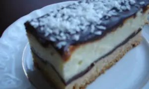 Szybkie ciasto z białym serem i budyniem, polane czekoladą i posypane wiórkami kokosowymi. Idealne na deser.