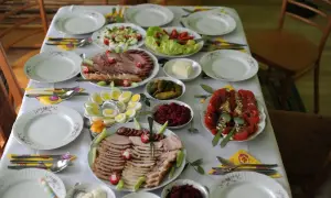 Wielkanocny stół ugina się od zimnych przystawek: wędlin, jajek, sałatek i warzyw.