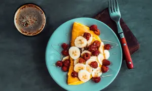 Słodki omlet z bananem i malinami, polany miodem. Idealny przepis na omlet na słodko na śniadanie.