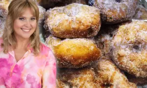 Uśmiechnięta Ewa Wachowicz prezentuje pączki z ziemniakami, posypane cukrem. Pyszne, domowe wypieki.