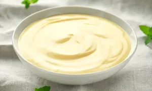 Gładki, kremowy custard w miseczce, ozdobiony listkami mięty. Pyszny deser, który rozgrzewa serce.