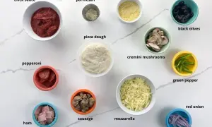 Pinsa z czym zrobić? Składniki: sos, parmezan, ciasto, pepperoni, szynka, kiełbaska, mozzarella, kukurydza, oliwki, pieczarki, papryka, cebula.