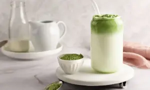 Idealny matcha latte przepis: zielony proszek, mleko i gotowy napój w szklance.