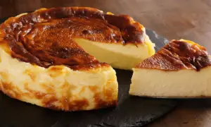 Pyszny, lekko przypieczony sernik na czarnej desce. Nawet jeśli sernik kcal kusi, warto spróbować!