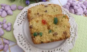 Keks stary przepis, z bakaliami i kandyzowanymi owocami, na ozdobnym talerzyku.