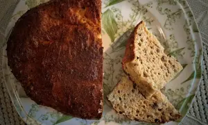 Chleb keto z twarogu i jajek, pyszny i puszysty, pokrojony na talerzu z konwaliami.