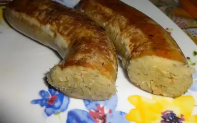 Dwie złociste kiszki ziemniaczane, pieczone do perfekcji, leżą na talerzu z kolorowymi kwiatami.