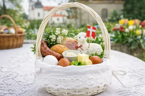 Biały koszyczek wielkanocny z barankiem, jajkami, kiełbasą i masłem. Idealny do święconki.