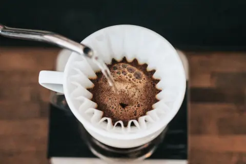 Kawa przelewa się przez filtr, tworząc aromatyczny drip.
