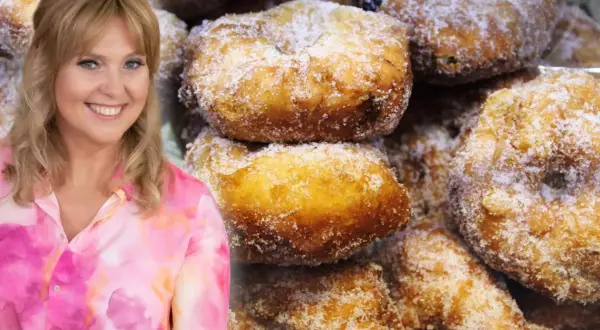 Uśmiechnięta Ewa Wachowicz prezentuje pączki z ziemniakami, posypane cukrem. Pyszne, domowe wypieki.