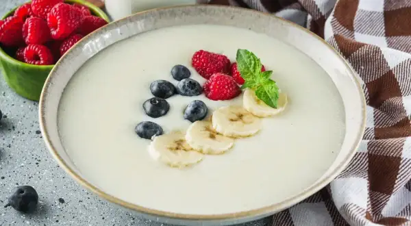 Idealne proporcje kaszy manny na mleku, podanej z malinami, borówkami i bananem. Pyszne śniadanie.