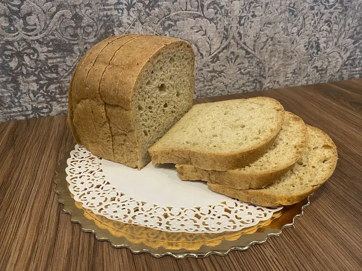 Pyszny keto chleb, idealny na śniadanie. Kromki ułożone na złotej paterze z koronkową serwetką.