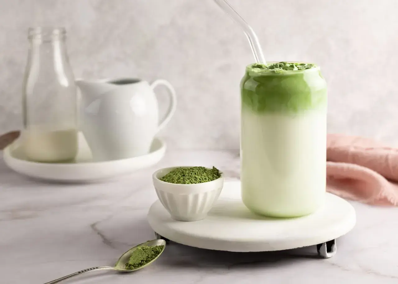 Idealny matcha latte przepis: zielony proszek, mleko i gotowy napój w szklance.