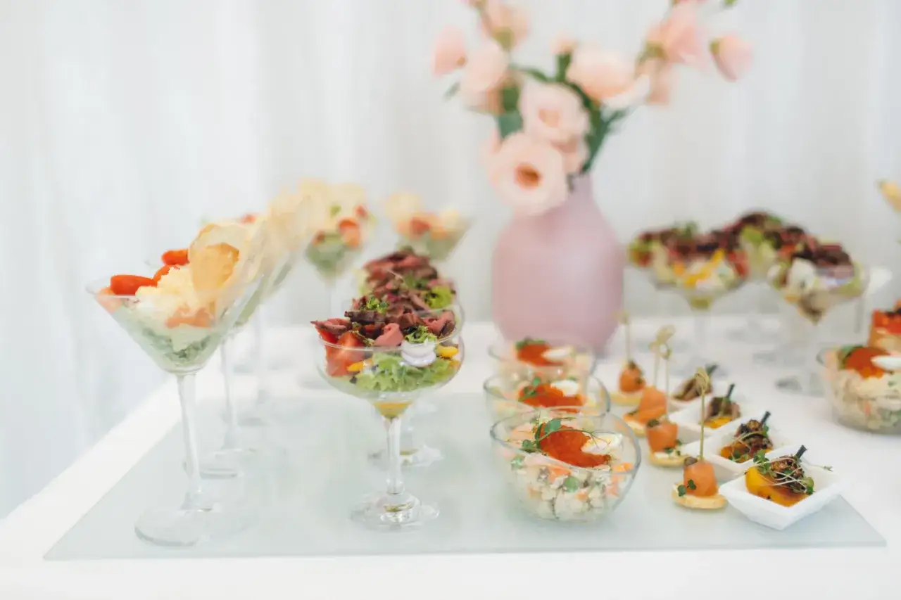 Eleganckie dania na komunie: sałatki w kieliszkach, koreczki z łososiem i mini przekąski.