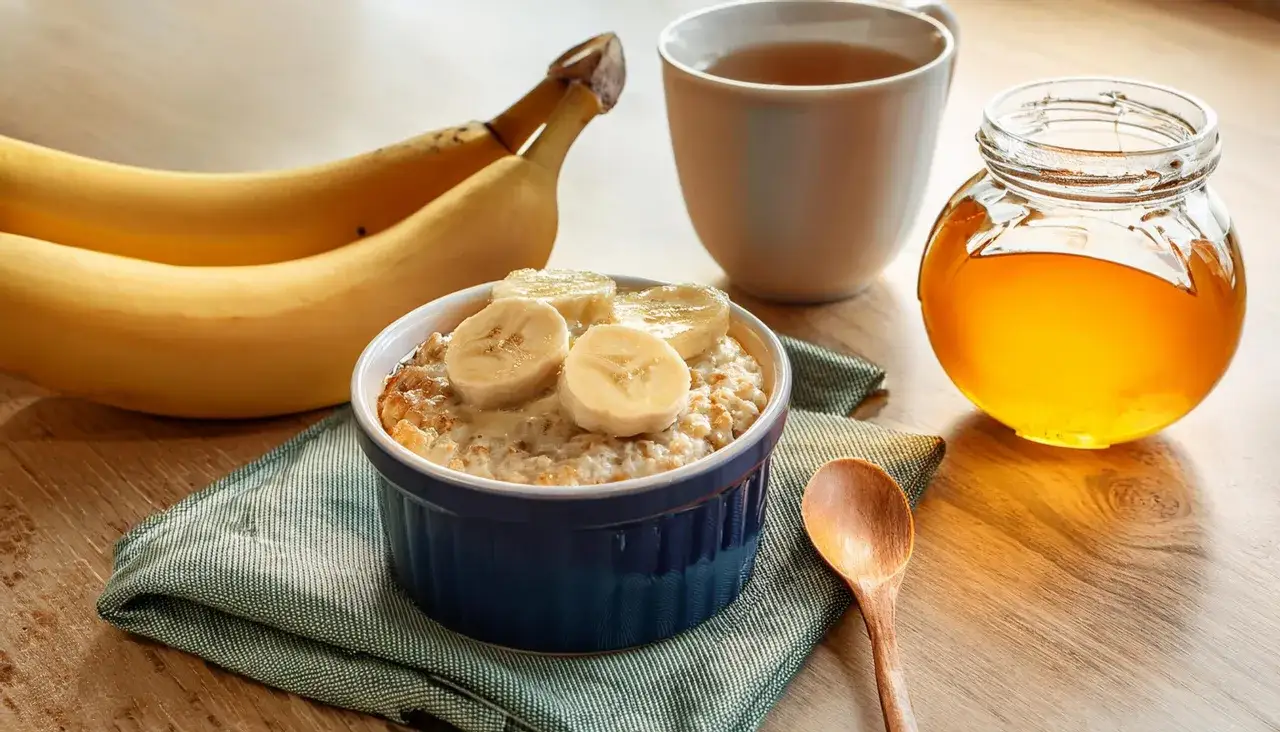 Pyszna pieczona owsianka z bananem z airfryera, obok miód i herbata. Idealne śniadanie.