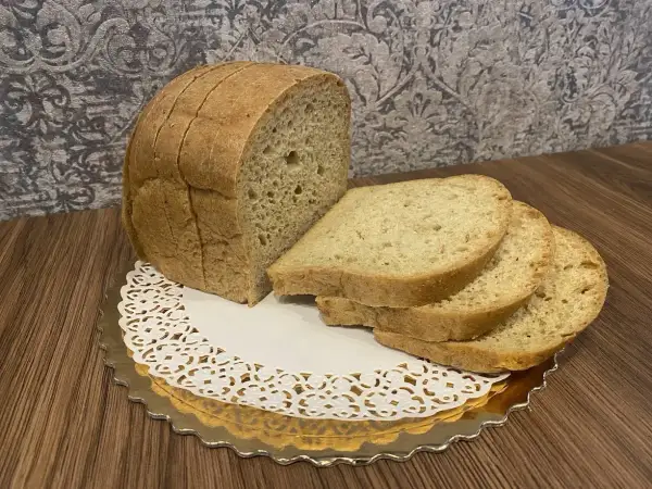 Pyszny keto chleb, idealny na śniadanie. Kromki ułożone na złotej paterze z koronkową serwetką.