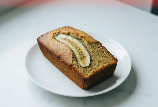 Chlebek bananowy z airfryera, idealnie wypieczony, z plasterkiem banana na wierzchu.